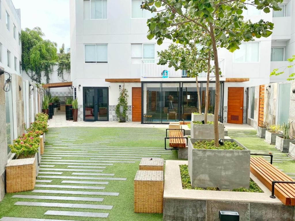 a courtyard with benches and a tree in a building at Osma by Wynwood House in Lima
