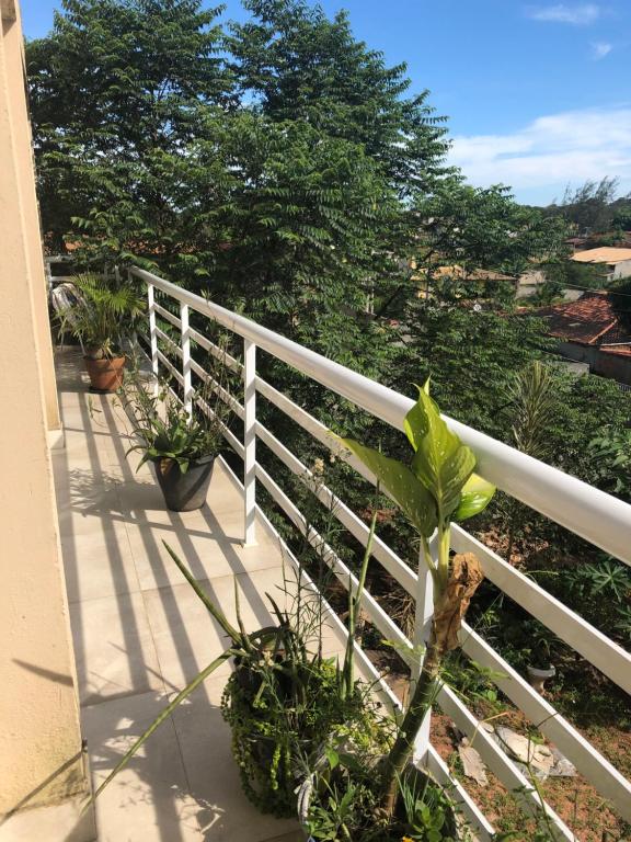 Una valla blanca con plantas en un porche. en Casa espaçosa cpm linda vista pro verde, en Búzios