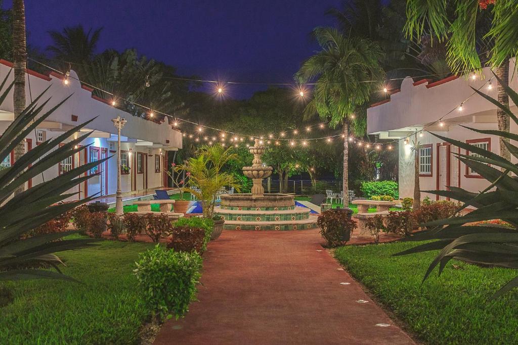 um jardim à noite com uma fonte e luzes em Hotel Lagoon - Pet Friendly em Chetumal