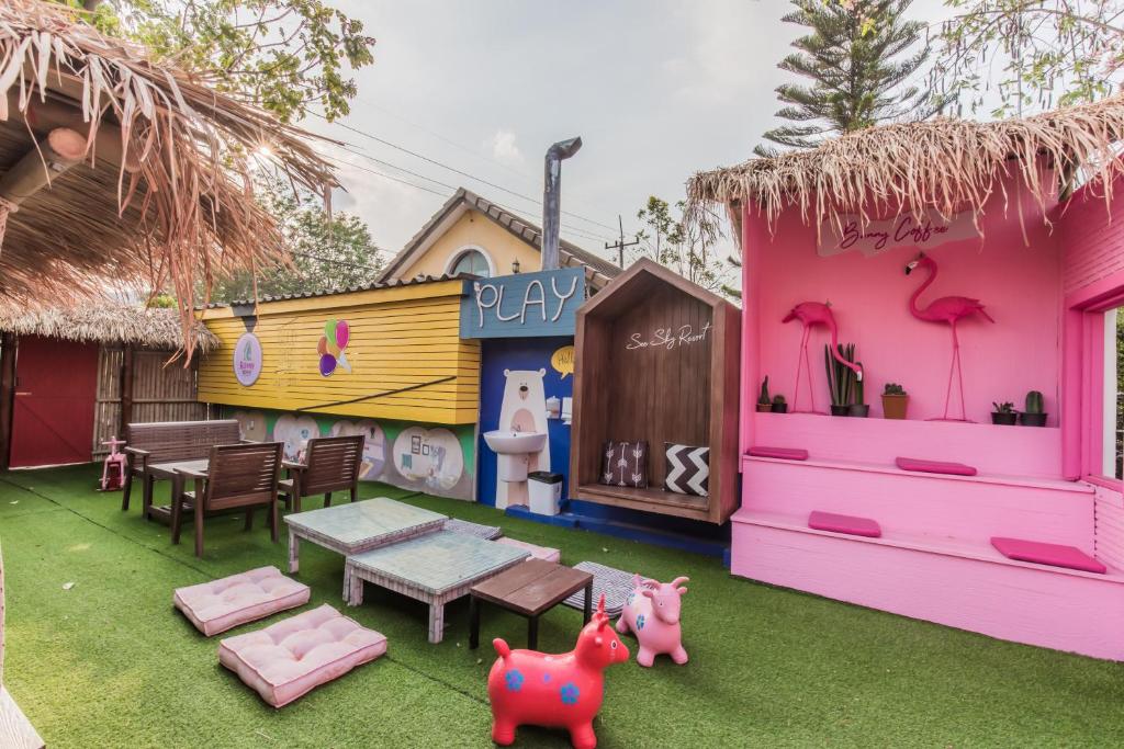 a backyard with a pink house with a pretend play area at See Sky Resort in Ban Sao Thong