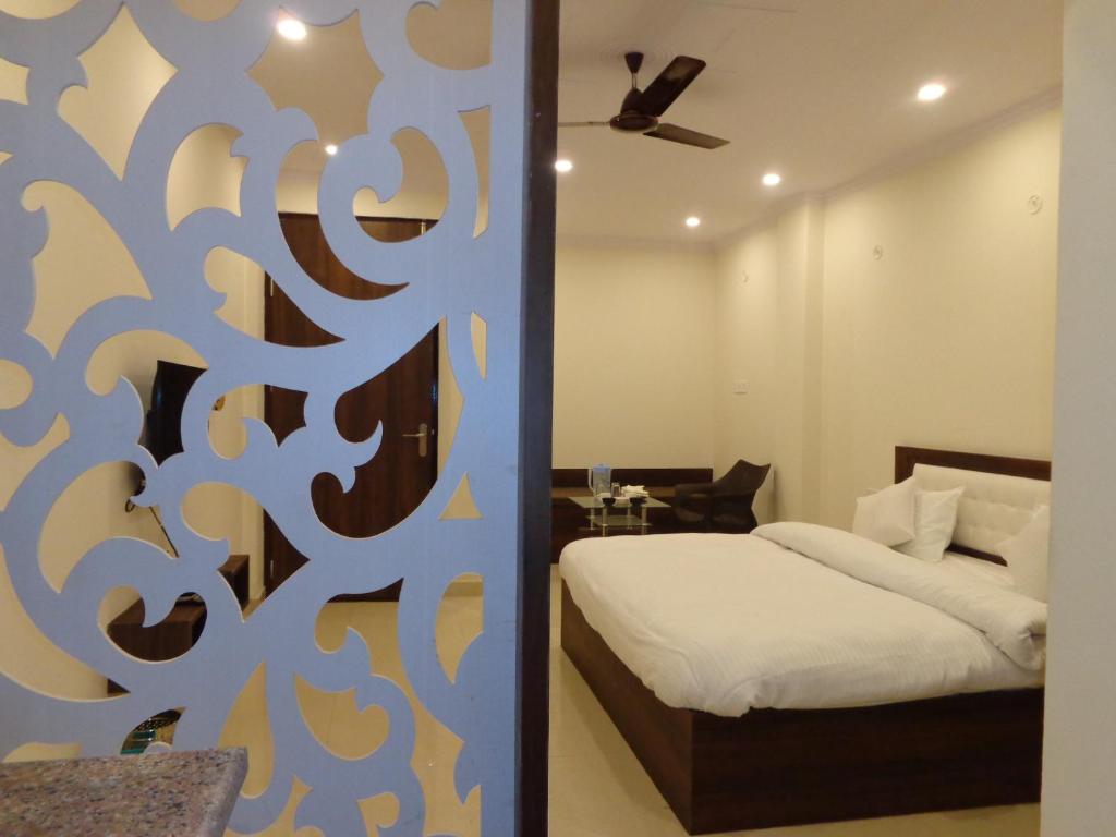 a bedroom with a bed and a room with aokedokedoked at Rukmani Inn in Vrindāvan