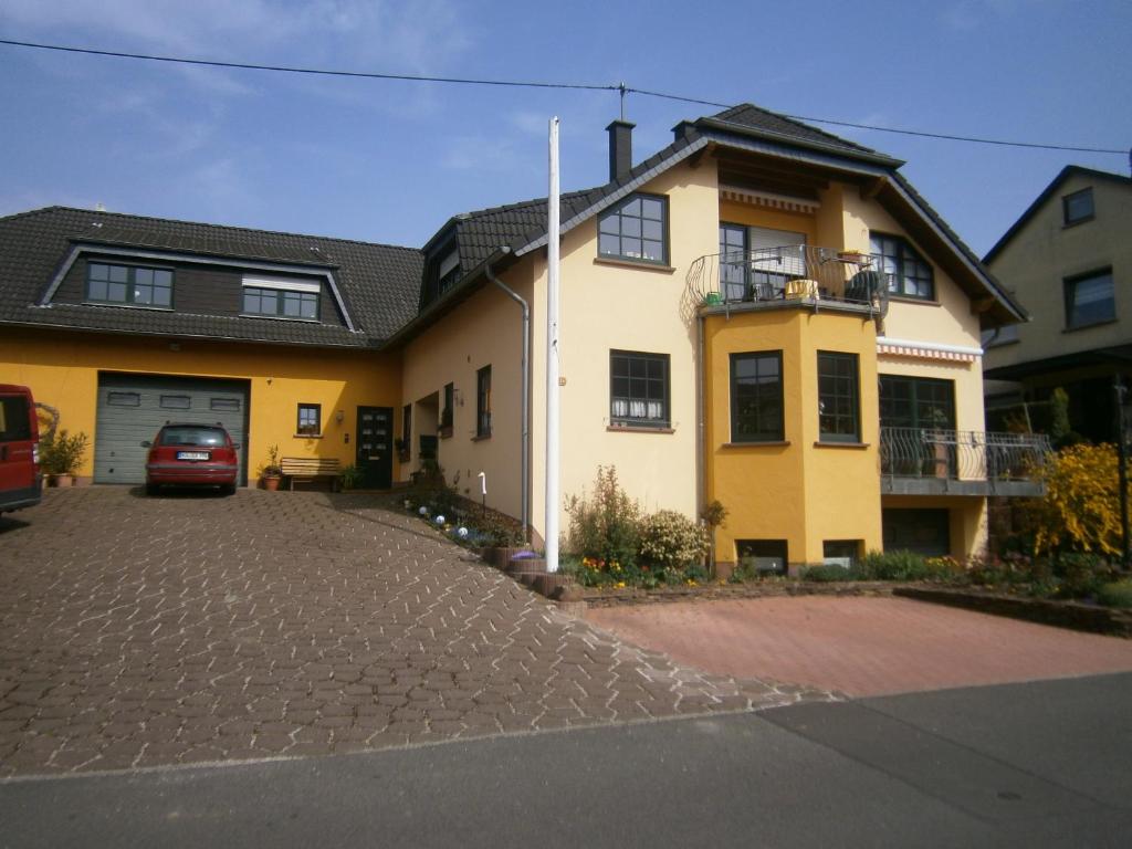 ein gelbes Haus mit einem davor geparkt in der Unterkunft Kappes-Koppelkamm in Zeltingen-Rachtig
