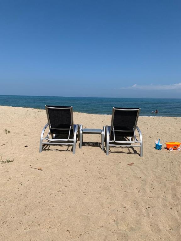 two chairs sitting on the beach near the ocean at Tranquility Bay Beach Retreat in Trujillo