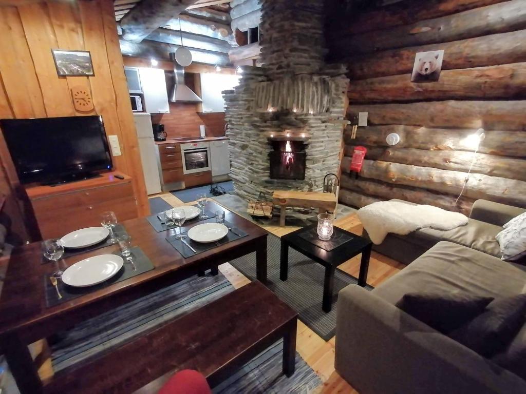 ein Wohnzimmer mit einem Tisch und einem Kamin in der Unterkunft Rantaruka Apartment in Ruka