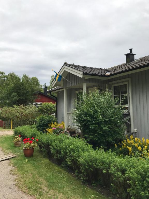 ein Haus mit Blumen und Pflanzen im Hof in der Unterkunft Sandbergen - strandnära fritidshus in Mörbylånga