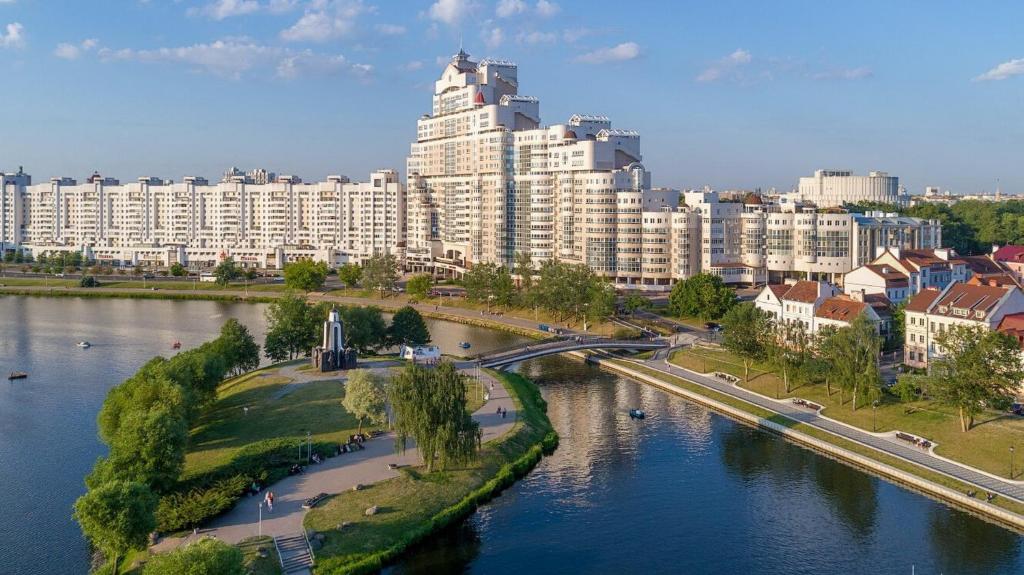 eine Stadt mit einem großen Gebäude neben einem Fluss in der Unterkunft Aparton in Minsk