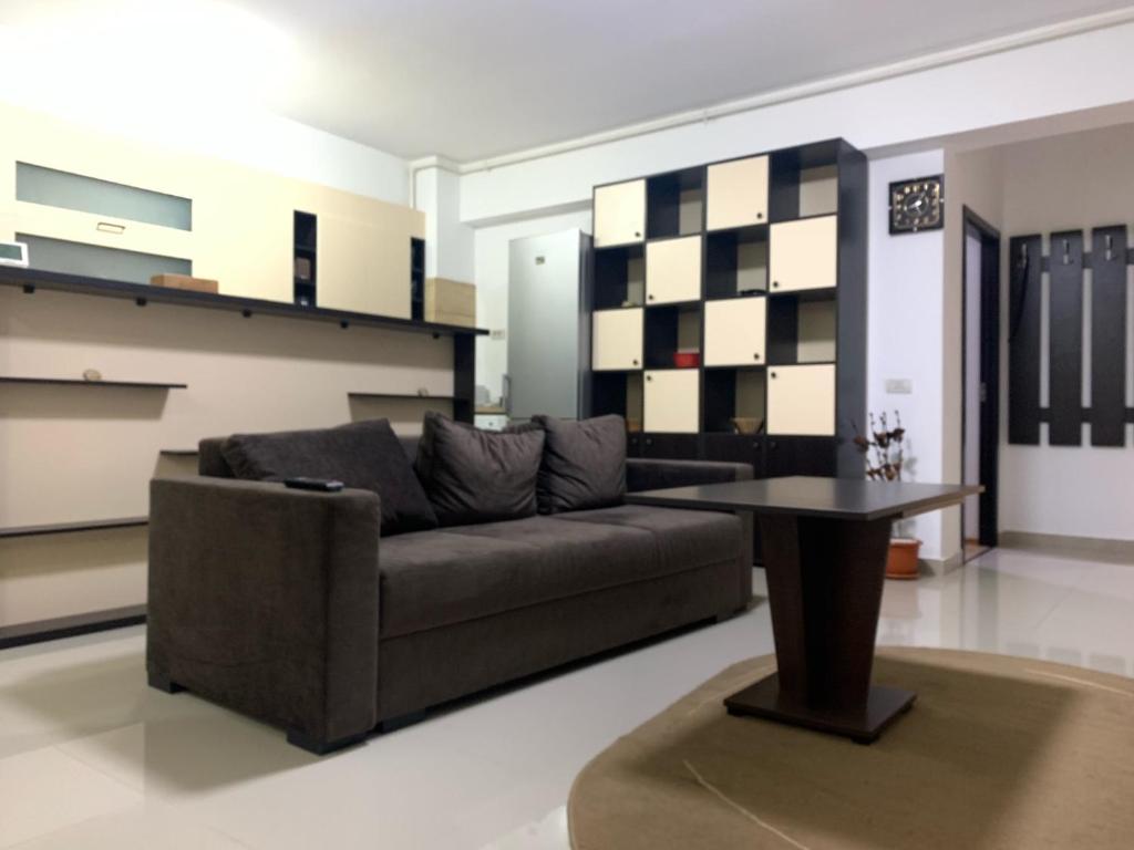 een woonkamer met een bank en een tafel bij Ferdinand Apartment in Constanţa
