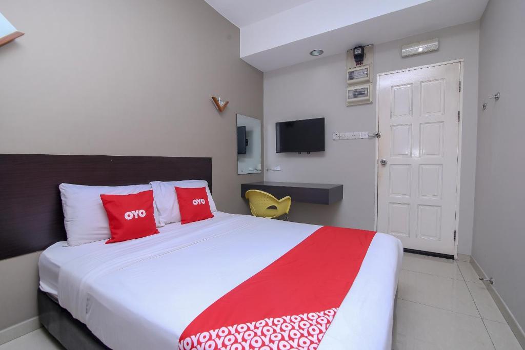 een slaapkamer met een groot bed met rode en witte kussens bij OYO 89959 Nice Stay Three Six Five Services in Kuching