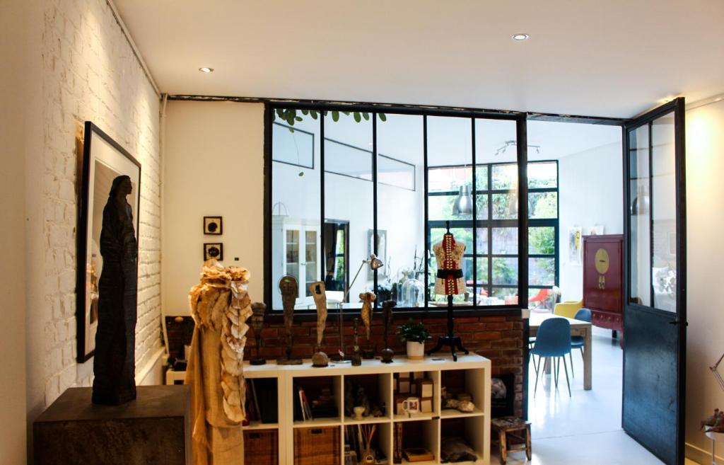 a living room with a large window and a table at Chambre d&#39;hôtes la Teinturerie in Roubaix