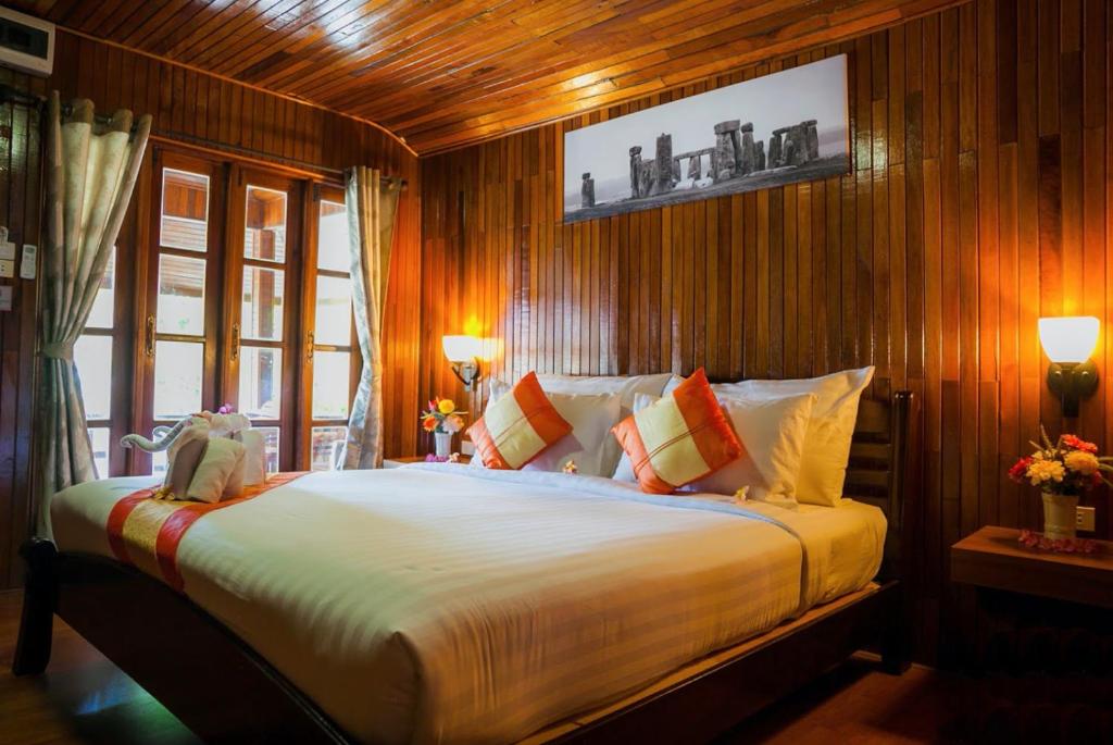 een slaapkamer met een groot bed en houten wanden bij Chareena Beachside in Ko Lipe