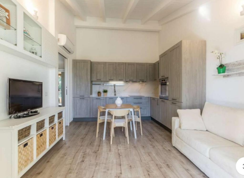uma sala de estar com um sofá e uma mesa em Modern cozy big balcony ENTIRE APARTMENT em Selargius