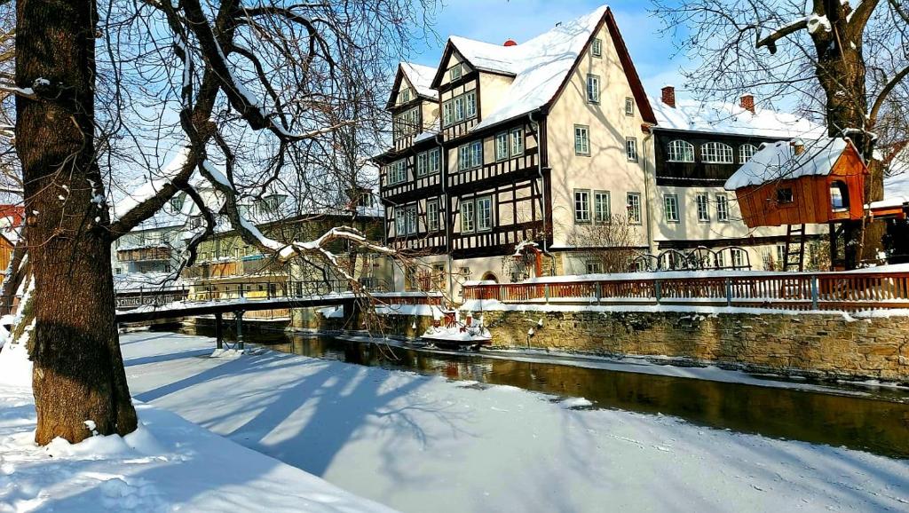 a large building on a river in the snow at Altstadtapartment an der Krämerbrücke Nr.2 in Erfurt