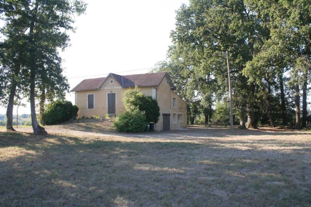 een huis in het midden van een veld met bomen bij Moulin de Bigorre in Saint-Genès-de-Castillon