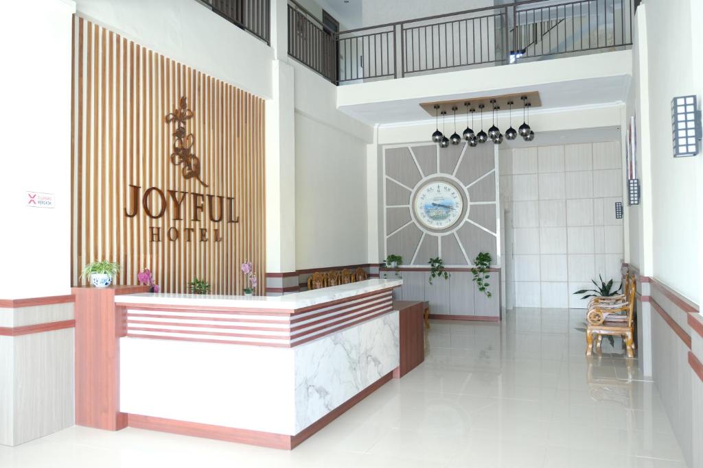 a lobby of a joliet hotel with a sign on the wall at Joyful Hotel in Tanjungpandan