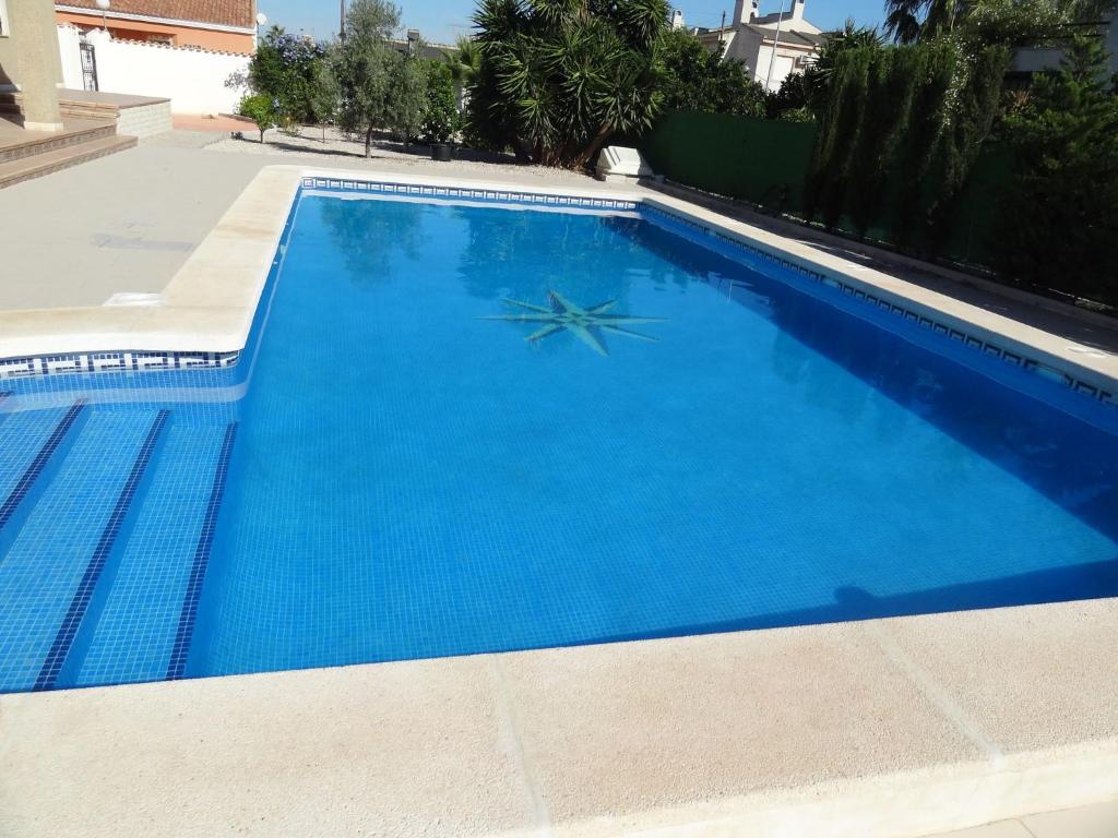 a large swimming pool with blue water at Superb villa for large families with large pool in San Fulgencio in La Marina