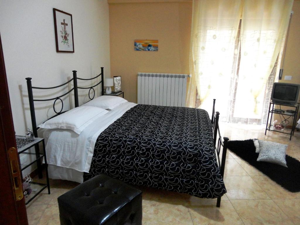 a bedroom with a black and white bed and a window at Case Vacanze Scimeca in Caccamo