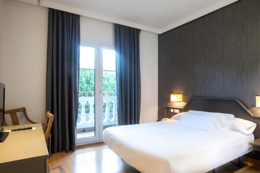 a hotel room with a bed and a window at Hotel Urdanibia Park in Irún