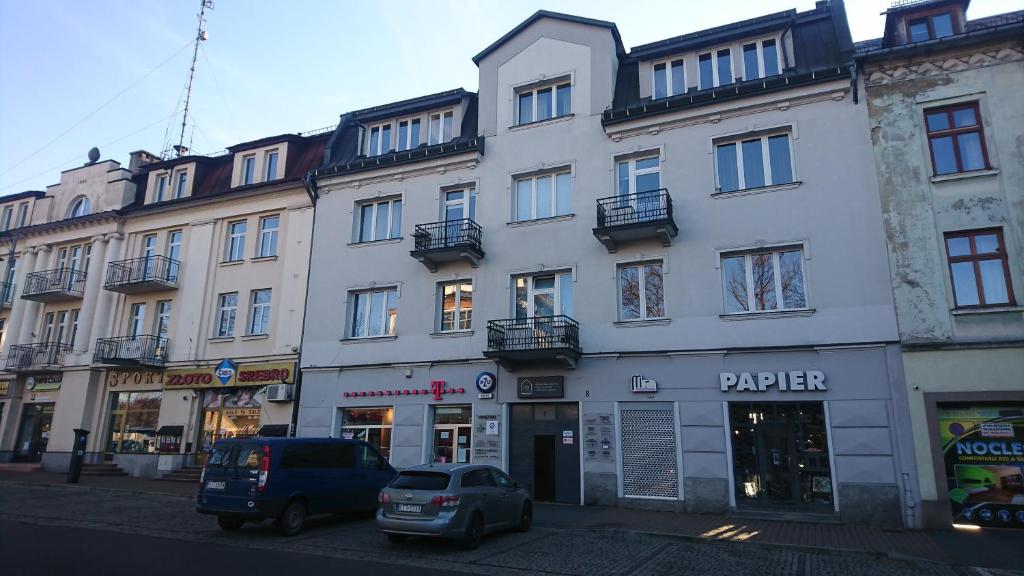 a large white building with cars parked in front of it at Apartamenty Kosciuszki 8 in Zakopane