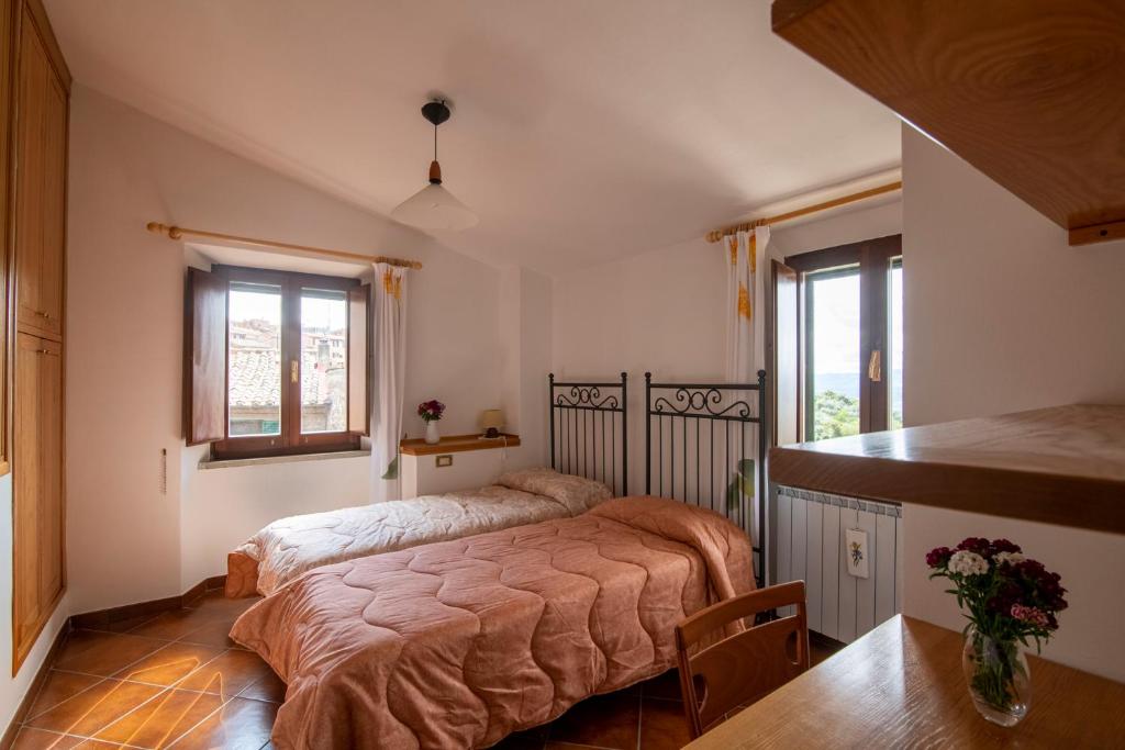 sypialnia z łóżkiem i 2 oknami w obiekcie CASA VIA DEL PERO w mieście Città della Pieve