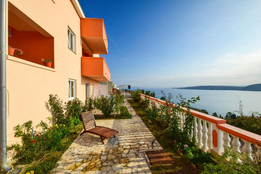 a chair sitting on a stone path next to a building at Apartments Komadina 596 in Vlašići