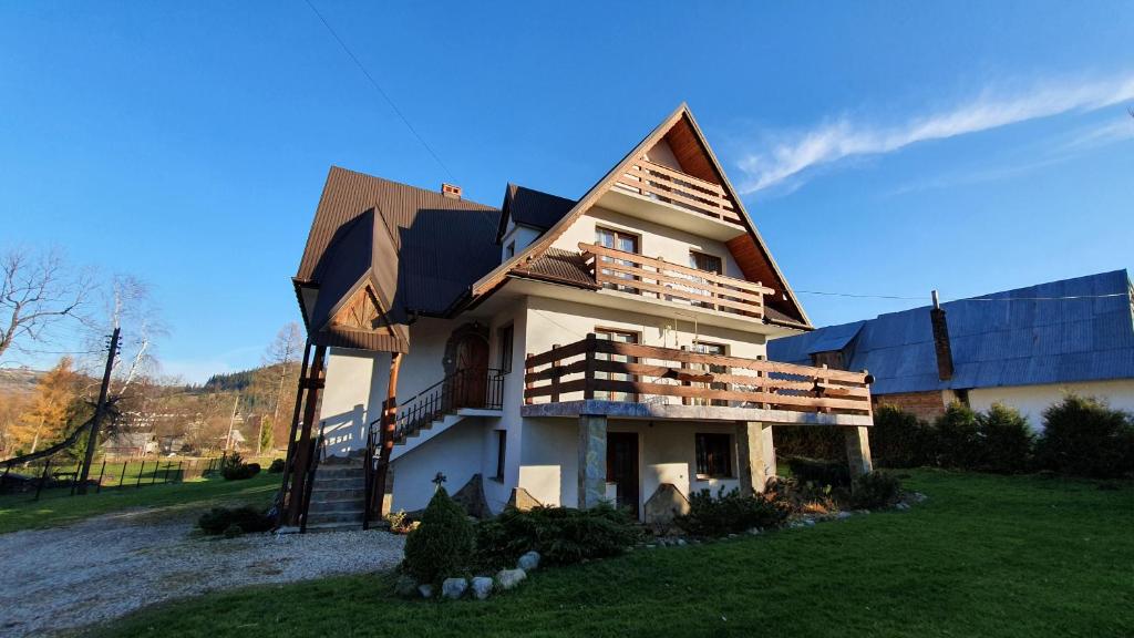 uma casa com um telhado de gambrel em cima dela em ZAKOporoniec em Poronin