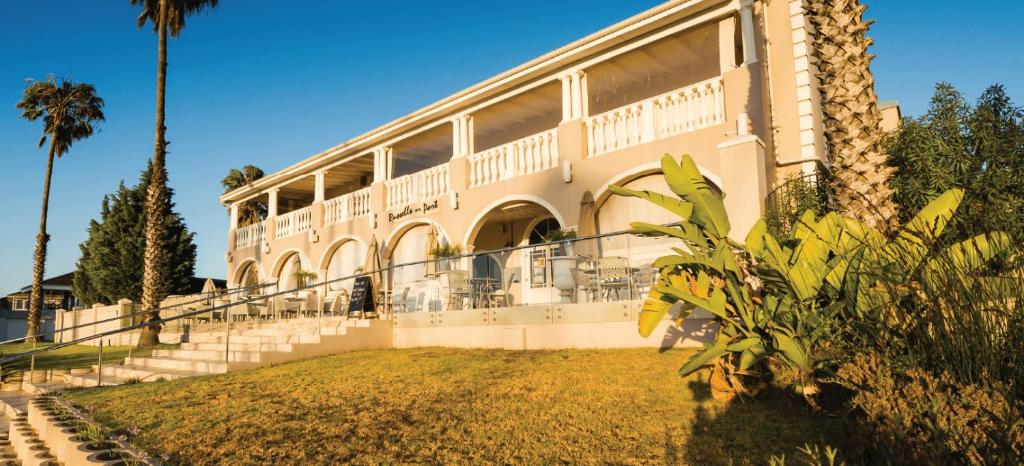 a large building with a balcony and palm trees at Russells on the Port in Velddrif