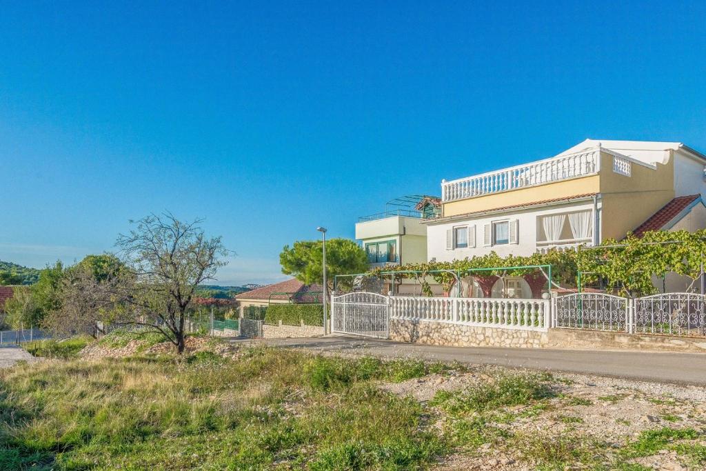 a house with a white fence in front of it at Apartments Ivić in Jadrtovac