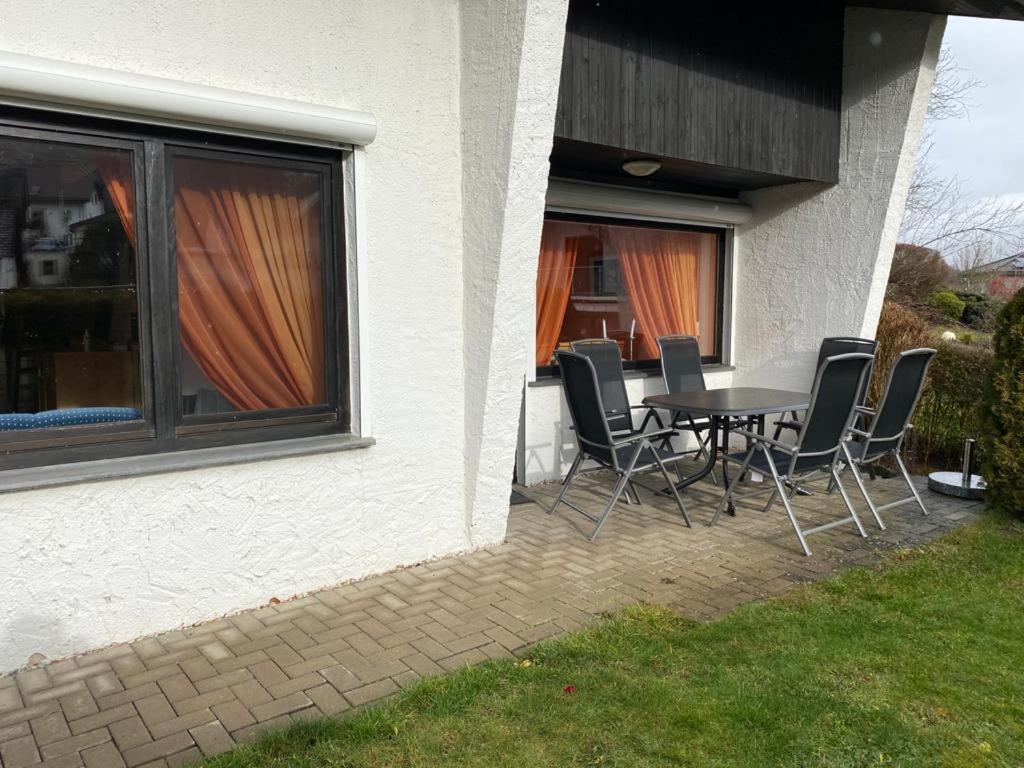 un patio con mesa y sillas junto a una casa en Ferienhaus Jüngling, en Wimbach