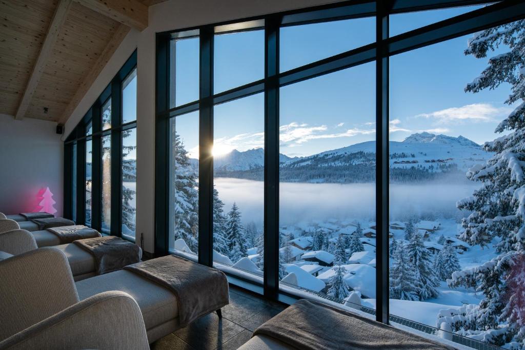 a room with a view of a snowy mountain at URSPRUNG Panorama Hotel Königsleiten in Königsleiten