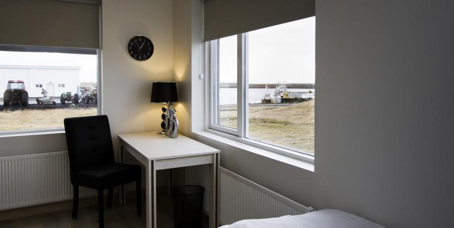 a bedroom with a desk and a chair next to a window at Mar Guesthouse in Grindavík