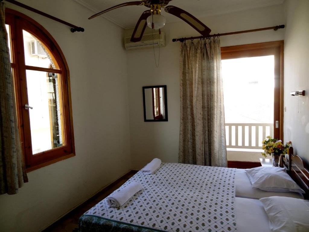 a bedroom with two beds and a window at Eleni's Rooms in Loutra Edipsou