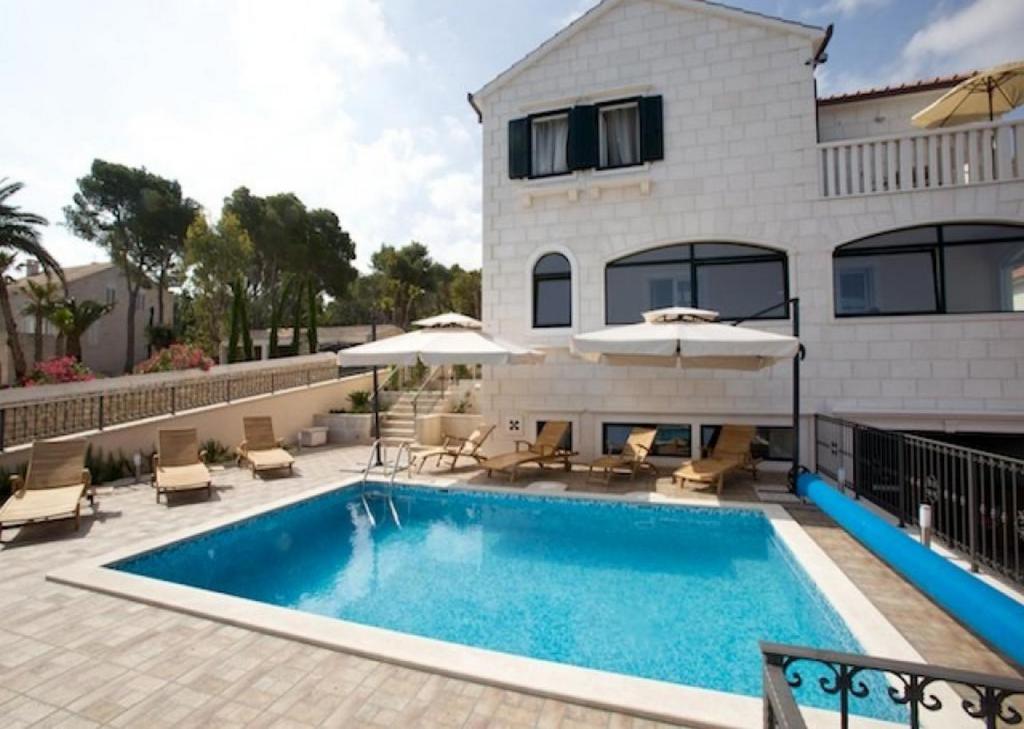 a swimming pool in front of a house at Apartments Grlica in Sutivan