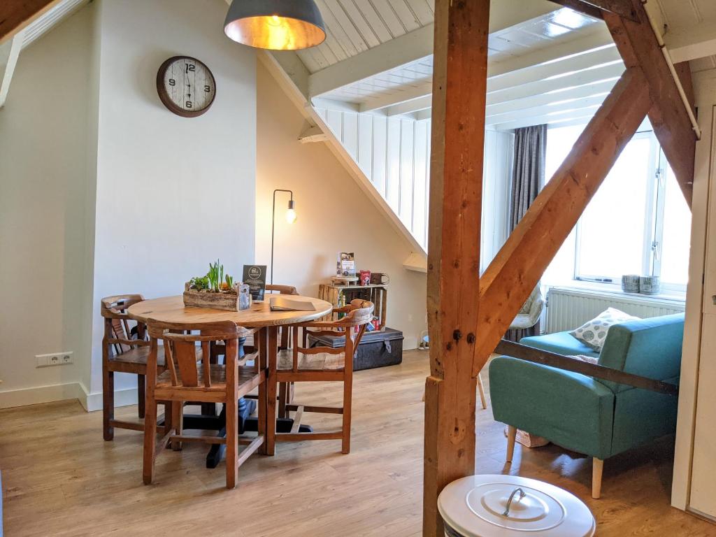 een eetkamer en een woonkamer met een tafel en stoelen bij CRASH'NSTAY - Weidezicht in Sprang-Capelle