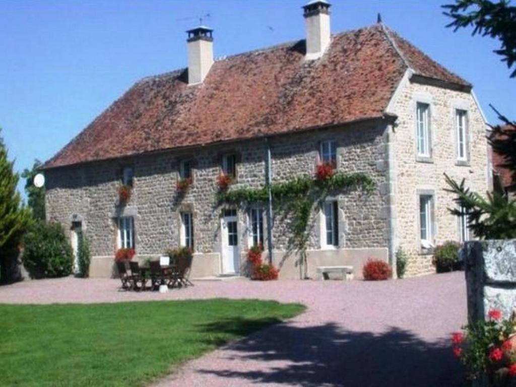 a large stone house with a roof at GITE Les Aubues in Lormes