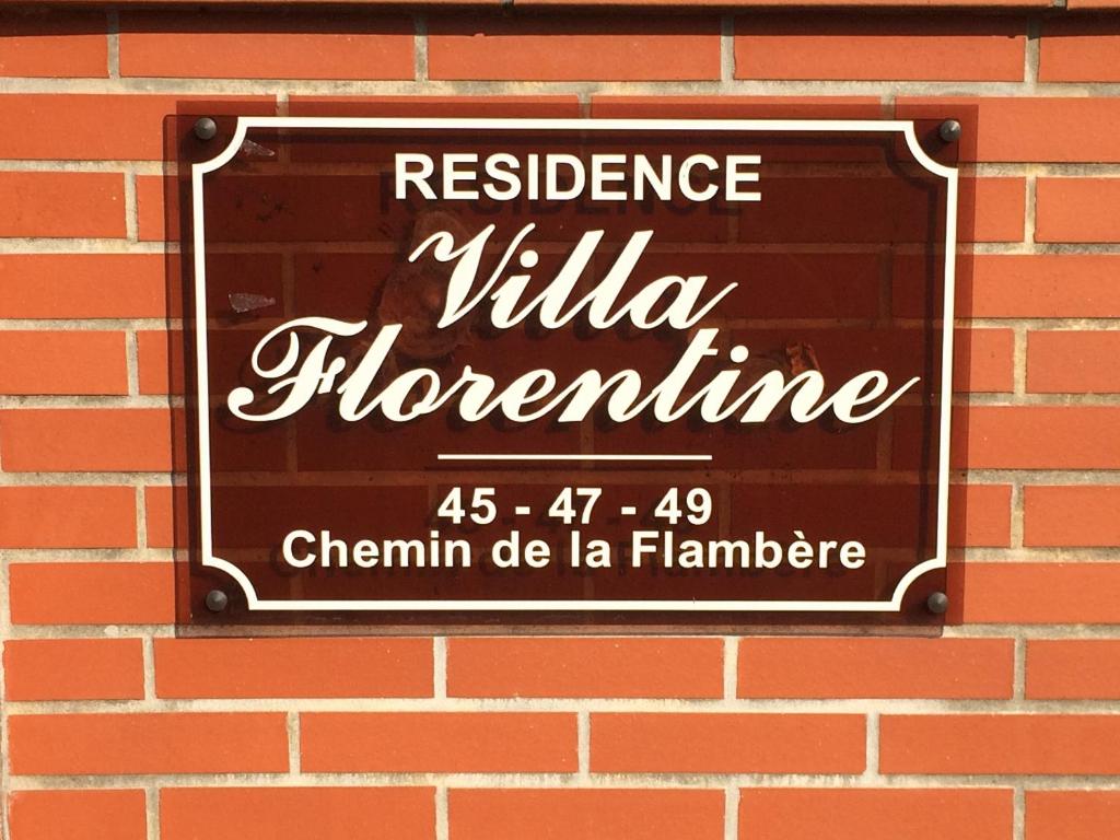 a sign on a brick wall that reads resilience villa florence at Les Florentines in Toulouse