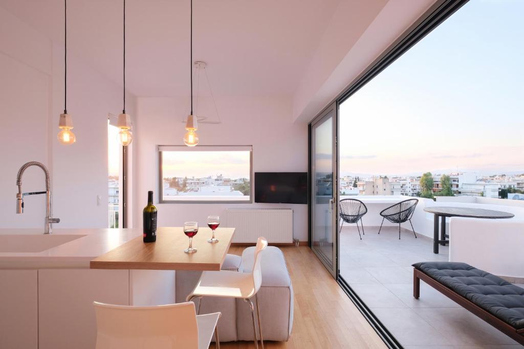 eine Küche und ein Wohnzimmer mit einem Tisch und Stühlen in der Unterkunft Amazing Suite at Glyfada with sea view & jacuzzi in Athen