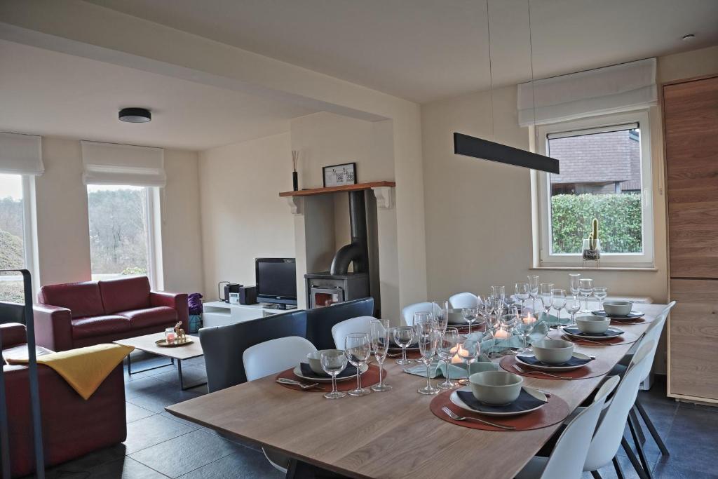 a dining room with a table with wine glasses on it at Maison Violette in Durbuy