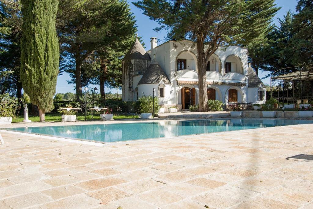 a large house with a swimming pool in front of it at Trulli Serralta by BarbarHouse in Locorotondo