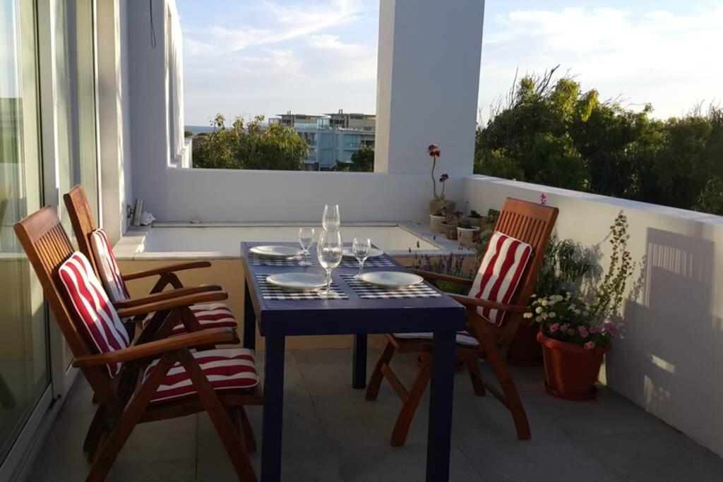 un tavolo blu e sedie sul balcone di Triplex con terraza única a 50 mts del mar a Carilo