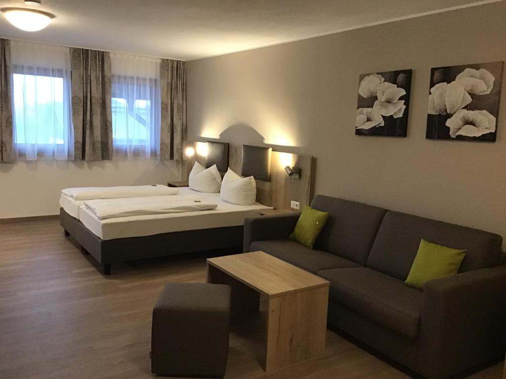 a hotel room with a bed and a couch at Gasthof Hotel Esterer in Rosenheim