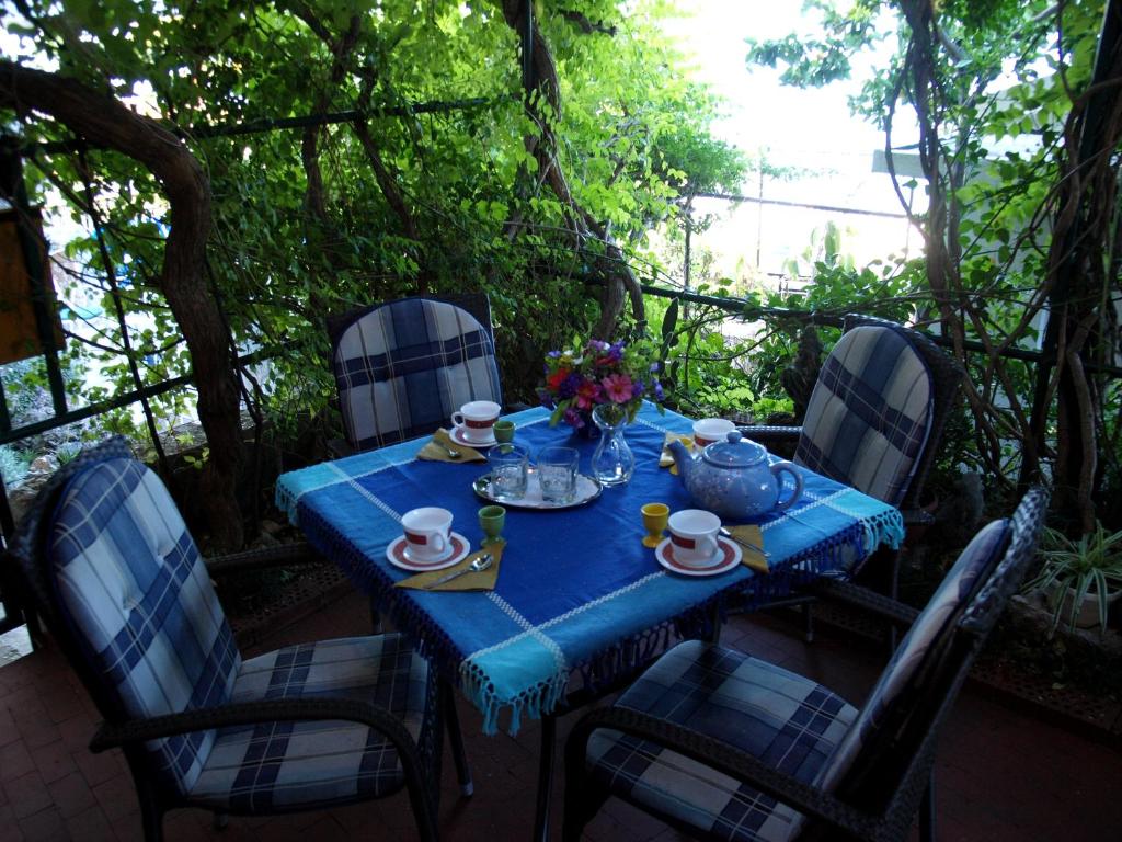 una mesa azul con sillas y una tetera en ella en Haus Franciska, en Podgora