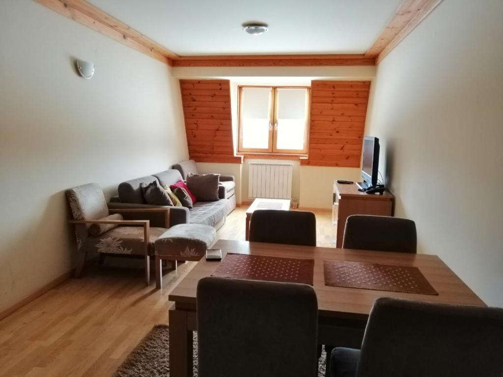 a living room with a couch and a table at Apartman 205- Aparthotel Vučko Jahorina private host 50m2 in Jahorina
