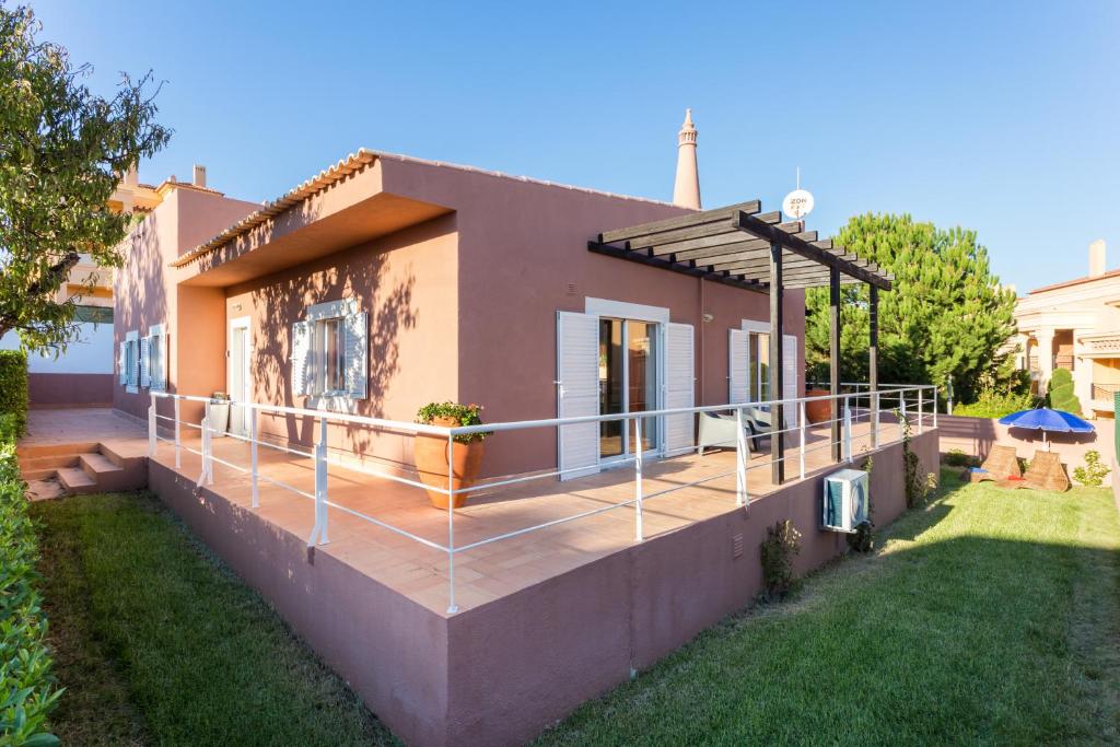 une maison avec une grande terrasse dans la cour dans l'établissement CoolHouses Algarve, Casa das Amendoeiras, V4 Praia da Luz, à Luz