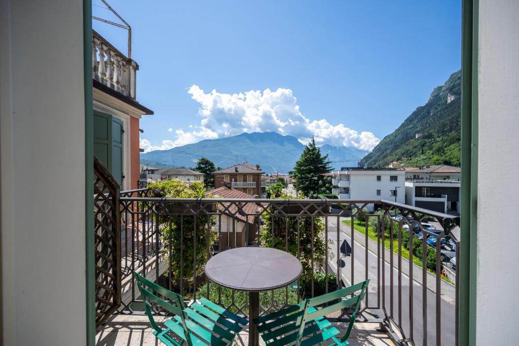 a balcony with a table and chairs and mountains at Villa Bellaria in Riva del Garda