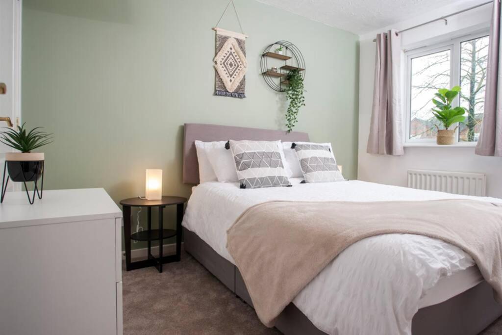 a bedroom with a large bed and a window at 3 Bed Townhouse Stafford in Stafford