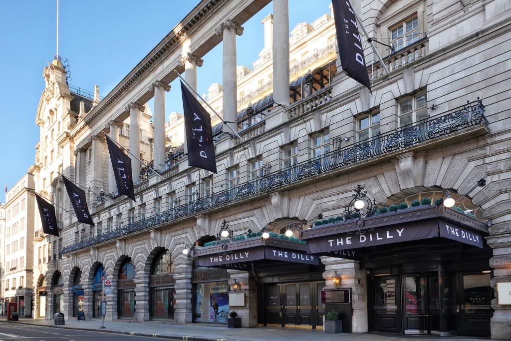 un grand bâtiment avec des drapeaux sur son côté dans l'établissement The Dilly, à Londres