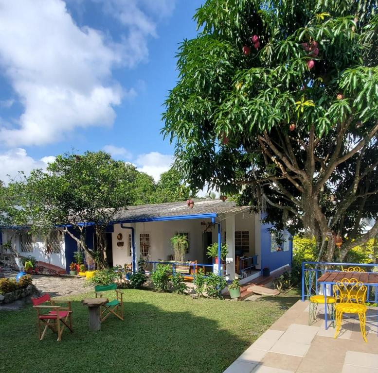 a house with a yard with chairs and a tree at El Piropo in La Vega