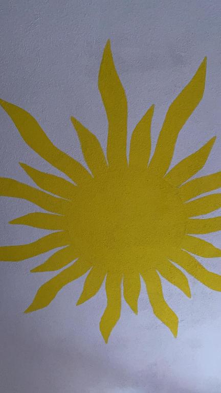 une conception jaune du soleil sur un mur dans l'établissement Paste&cannola, à Lampedusa
