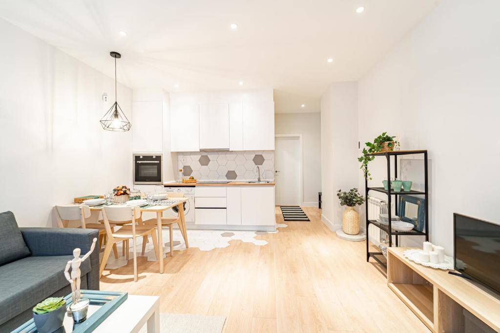 EdSam Madrid Apartments White في مدريد: غرفة معيشة ومطبخ مع أريكة زرقاء
