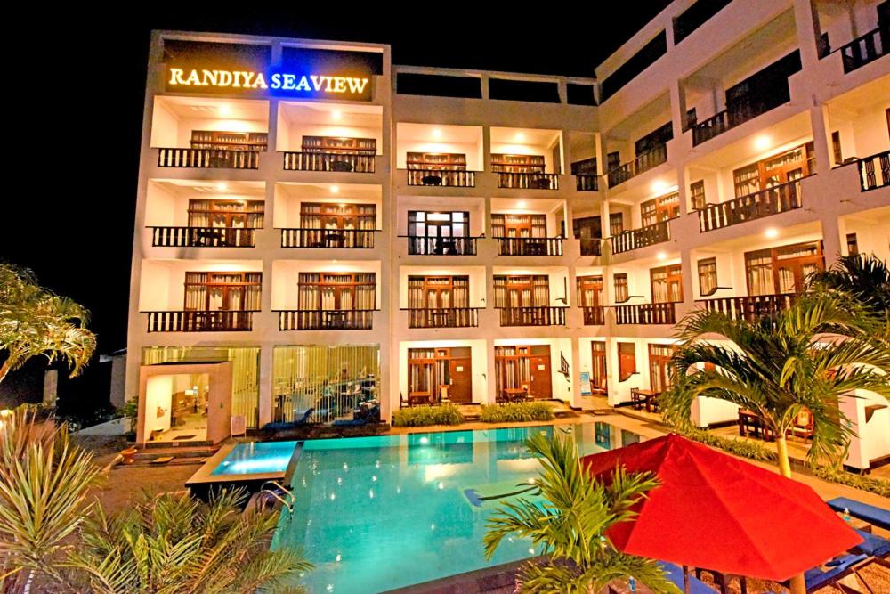 a hotel with a swimming pool in front of a building at Randiya Sea View Hotel in Mirissa